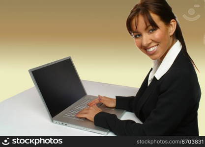 An attractive young woman working on a computer using a mouse.