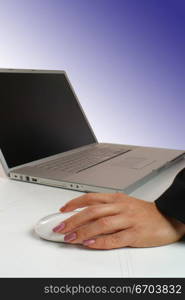 An attractive young woman working on a computer using a mouse.