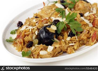 An authentic Saudi chicken kabsa (known in Qatar as majbous), garnished with raisins, parsley and toasted almond flakes, on a serving bowl. Kabsa is a national staple for Saudi Arabia and the Arab Gulf States.