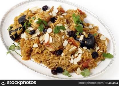 An authentic Saudi chicken kabsa (known in Qatar as majbous), garnished with raisins and toasted almond flakes, on a serving bowl. Kabsa is a national staple for Saudi Arabia and the Arab Gulf States.