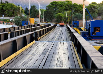 An automobile and pedestrian bridge over the Corinth Canal in Greece, which is flooded as ships and boats pass through the canal, image with copy space.. Submersible bridge over the Corinth Canal, a car rides along the bridge, close-up.