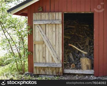 An axe and the woodpile inside a storage