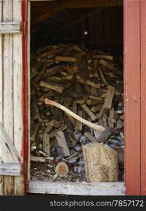 An axe and the woodpile inside a storage