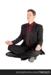 An business man in a suit sitting on the floor, glossing his eye&rsquo;sin a yoga pose, isolated on white background.
