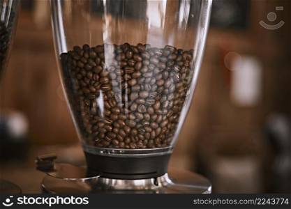 An coffee bean grinder next to an espresso maker in a coffee shop . coffee bean grinder