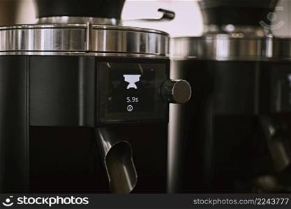 An coffee bean grinder next to an espresso maker in a coffee shop . coffee bean grinder
