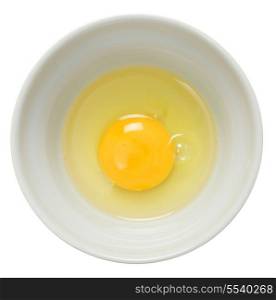 An egg broken into a bowl and seen from above over a white background.