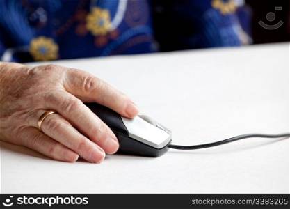 An elderly hand on a computer mouse