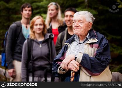 An elderly man giving a tour for a young group of people