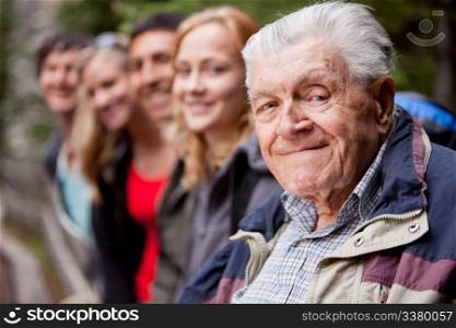 An elderly man in front of a group of young people