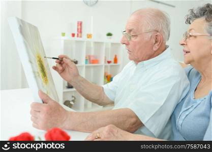 an elderly man is painting