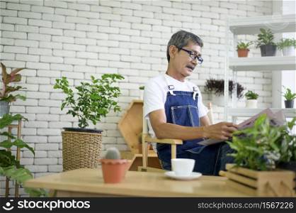 An elderly man is relaxing with coffee and reading Newspaper at his home .. An elderly man is relaxing with coffee and reading Newspaper at his home
