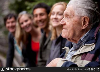 An elderly man telling stories to a group of young people in the forest
