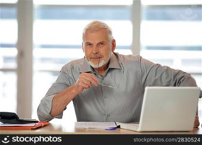 An elderly man using his laptop