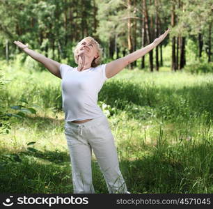 An elderly woman practices yoga in nature. The symbol of healthy lifestyle