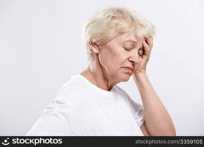 An elderly woman rests her head on a white background