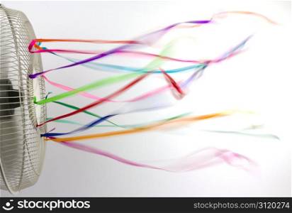 An electric fan blurring colorful silk ribbons