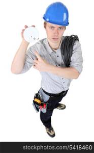 An electrician holding a fire alarm.