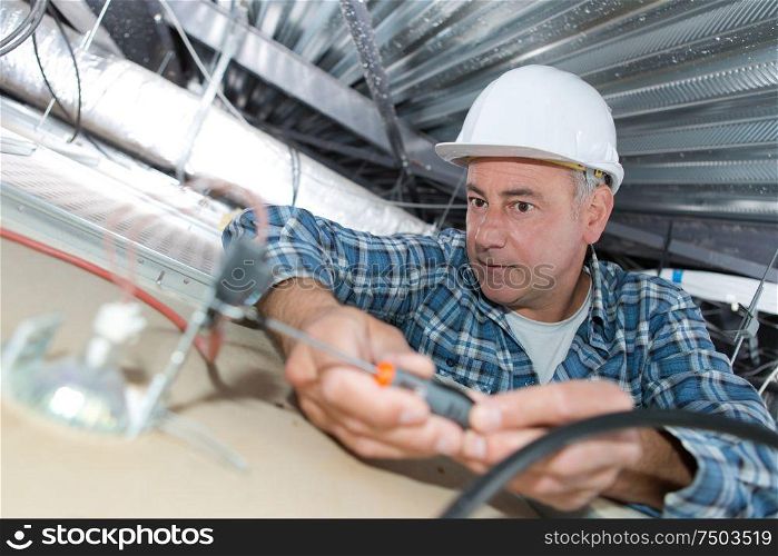 an electrician installing ceiling light