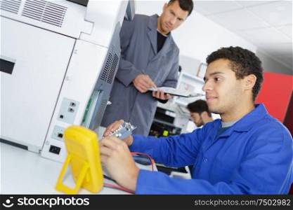 an electrician is inspecting printer