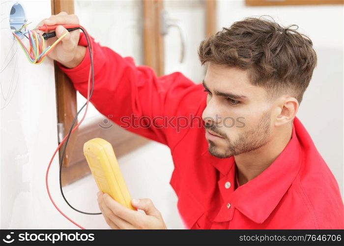 an electrician technician working on socket measurement
