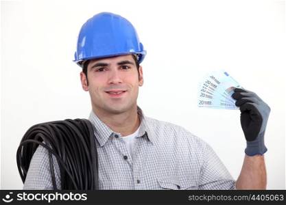 An electrician with his hand full of cash.
