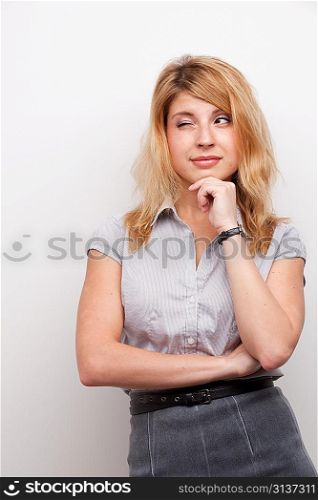 An elegant young woman winking at us on a light gray background