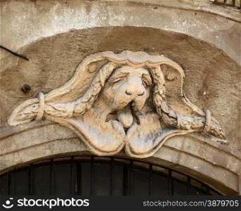 An emblem of a sleepy dog is located over a door way in Aix en Provence in Southern France.