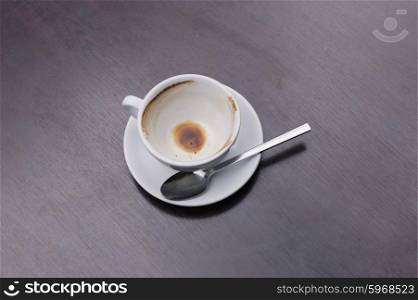 An empty cup of coffee with a spoon on a table