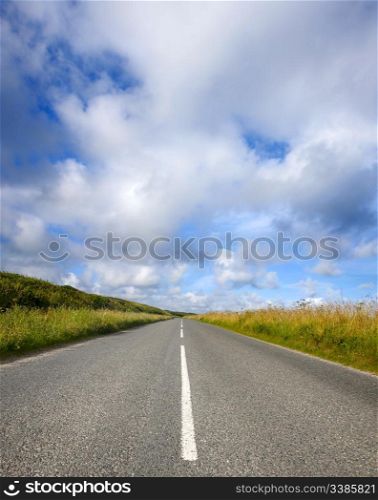 An empty English countryside road and a big sky in Cornwall.