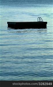 An empty floating dock on calm water.