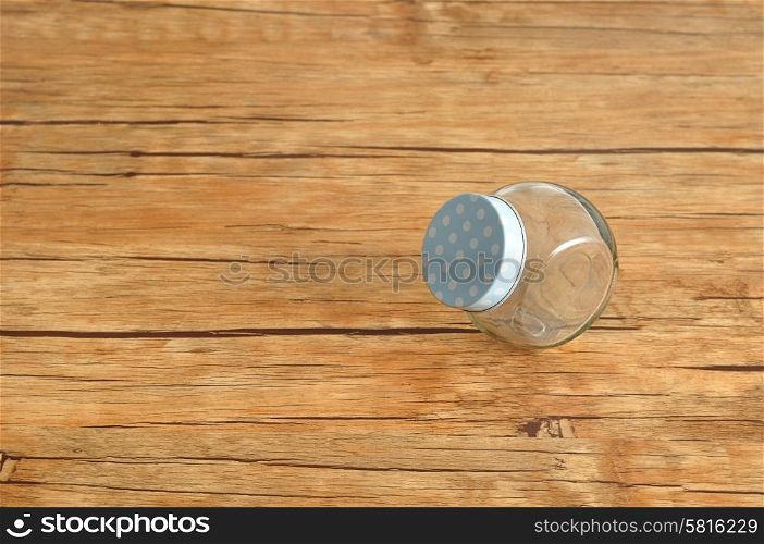 An empty glass container isolated on a wooden background