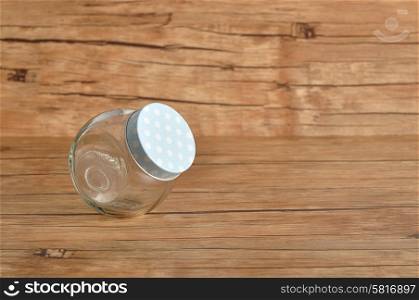 An empty glass container isolated on a wooden background
