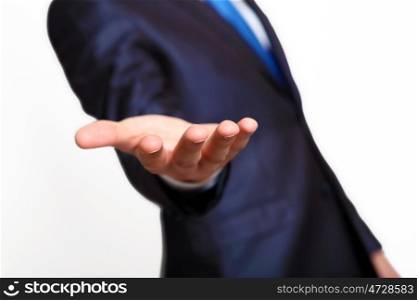 An empty hand of a businessman in blue suit