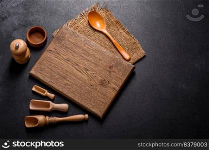 An empty wooden cutting board with wooden cutlery. Preparing the kitchen table for cooking. An empty wooden cutting board with wooden cutlery