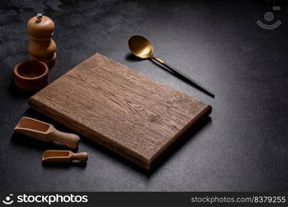 An empty wooden cutting board with wooden cutlery. Preparing the kitchen table for cooking. An empty wooden cutting board with wooden cutlery