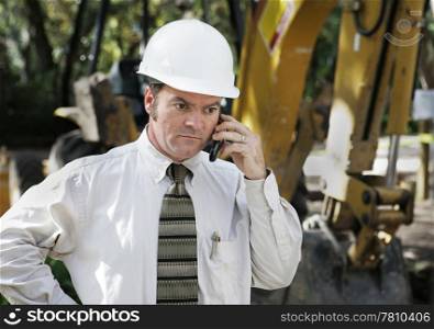 An engineer talking on the phone at the construction site.