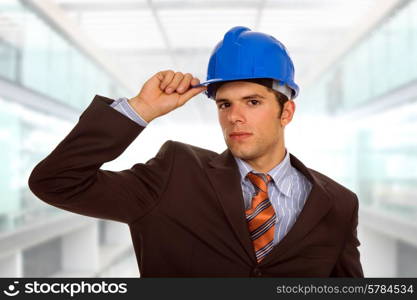 An engineer with blue hardhat, at the office