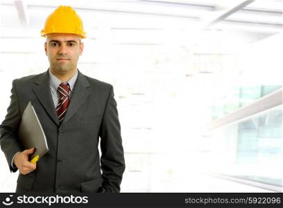 An engineer with yellow hat inside a modern building