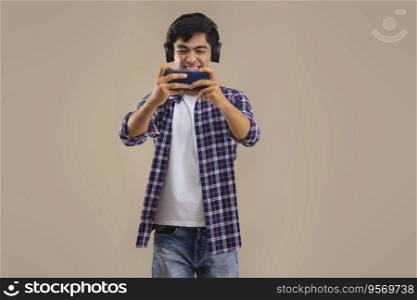 AN ENTHUSIASTIC TEENAGER PLAYING VIDEO GAME ON MOBILE PHONE