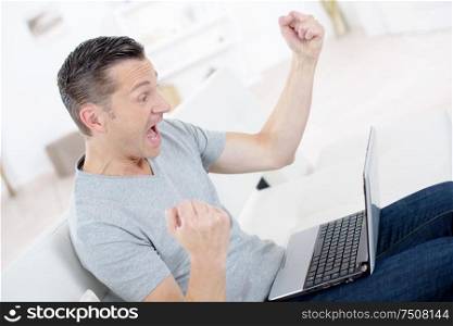 an excited man with laptop