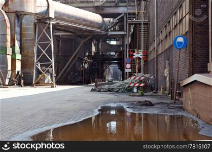 An gloomy, dim alley at a heavy industrial plant