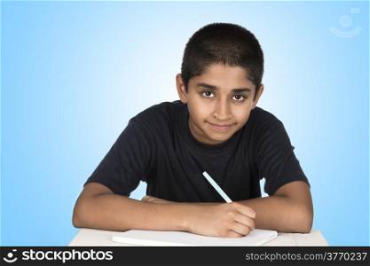 An handsome Indian kid doing his homework diligently