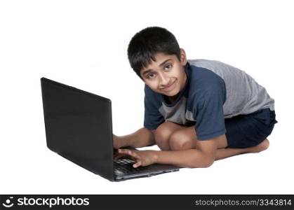 An handsome Indian kid having fun with laptop