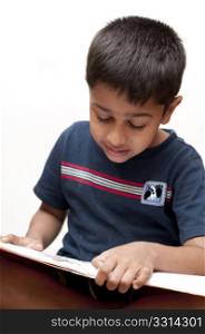 an handsome Indian kid reading his homework