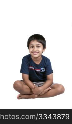 An handsome Indian kid sitting and smiling