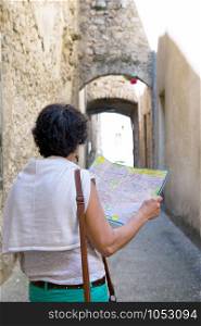 an happy female tourist searching road on map in city during vacation