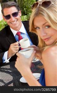 An happy handsome businessman and attractive woman couple having coffee togther at an outdoor cafe or retsaurant table