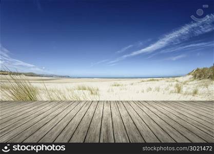An image of a beach and a wooden jetty in the forground