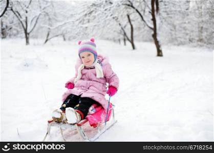 An image of a child sitting on sledge